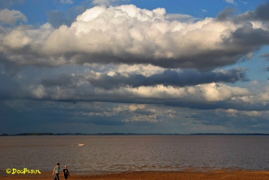 Foto 1/En la playa con sol y nubes