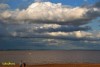 En la playa con sol y nubes