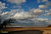 En la playa con sol y nubes