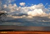 En la playa con sol y nubes